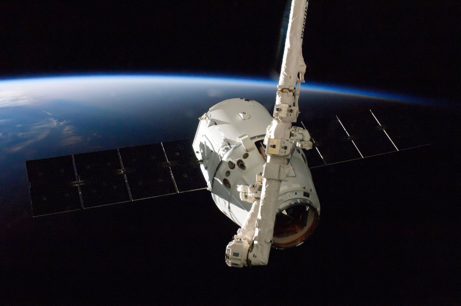 SpaceX Dragon kapsula v dokovacej pozícii – ilustrácia satelitných misií